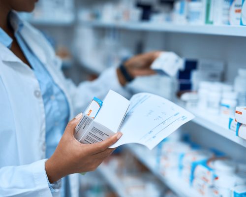 Cropped shot of a pharmacist filling a prescription at a chemist